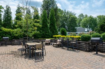 a patio with tables and chairs on a brick patio